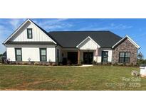 Charming single-story home featuring a well-manicured lawn, stone accents, and a welcoming front porch at 335 Young Rd, Salisbury, NC 28144