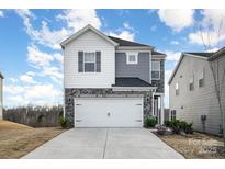 Two-story home with gray and white siding, stone accents, and a two-car garage at 345 Hyssop Ct, Fort Mill, SC 29715