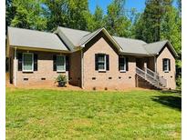 Lovely brick home with a well-manicured lawn and traditional architectural details at 395 Paulownia Dr, China Grove, NC 28023