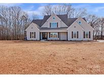 Two-story farmhouse with gray siding, dark brown accents, and a covered porch at 4105 Parkwood School Rd # Lot 4, Monroe, NC 28112