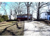 Ranch style home with gray and red siding, driveway, and small yard at 1750 Oak Valley Dr, Gastonia, NC 28054