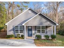 Gray exterior of charming house with landscaping and a driveway at 275 Broad Sw Dr, Concord, NC 28025