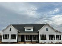 Two-story farmhouse with white siding, dark shutters, and a gray roof at 2906 Lathan Rd, Monroe, NC 28112