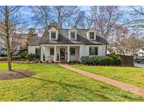 Charming brick home with manicured lawn, brick walkway, and covered front porch swing at 373 Hillside Ave, Charlotte, NC 28209