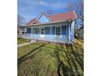 Charming blue home with a metal roof and covered front porch, perfect for relaxing outdoors at 414 S Yadkin Ave, Spencer, NC 28159