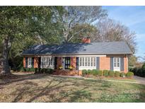 Brick ranch house with a landscaped lawn and mature trees at 4308 Glenfall Ave, Charlotte, NC 28210