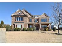 Charming two-story brick home with symmetrical design, manicured landscaping, and welcoming front porch at 5600 Ballenger Ct, Waxhaw, NC 28173