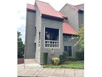 Exterior view of a gray condo building with a red roof and landscaping at 9041 J M Keynes Dr # 10, Charlotte, NC 28262