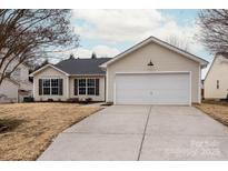 Beige house with white garage door and landscaping at 13311 Arbor Meadows Ct, Charlotte, NC 28269