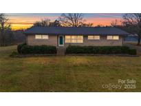 Charming brick home with manicured hedges and a spacious front yard under a colorful sky at 20329 Efird Rd, Albemarle, NC 28001