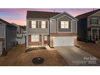 Two-story house with brick and siding, attached garage, and a well-manicured lawn at 3914 Waxahachie Ave, Charlotte, NC 28214