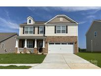 Charming two-story home featuring a brick facade, white trim, and a two-car garage at 9142 Mackinaw Dr, Gastonia, NC 28056