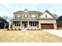 Two-story brick home with a large front porch and a three-car garage at 9811 Ardley Park Way # 30, Mint Hill, NC 28227