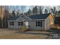 Charming single story home with gray vinyl siding, black shutters, and a cozy front porch at 118 Valley Springs Dr, Olin, NC 28660