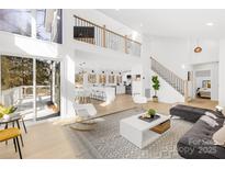 Bright open concept living room with modern decor, light wood floors and lots of natural light at 126 Abbey Ln, Mount Gilead, NC 27306