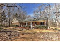 Charming brick home featuring a covered front porch and well-maintained landscaping at 2205 E Brief Rd, Monroe, NC 28110