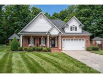 Brick and shingle front elevation of charming home with landscaping and two-car garage at 2324 Ryan Conley Ct, Gastonia, NC 28056