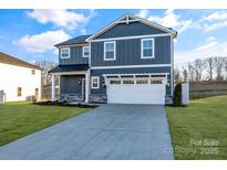 Two-story house with gray siding, white garage door, and landscaping at 3040 Swallowtail Ln # 36, Kannapolis, NC 28083