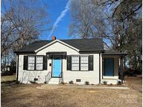 Charming white house with black shutters, light blue door, and a well-maintained yard at 407 E Talleyrand Ave, Monroe, NC 28112