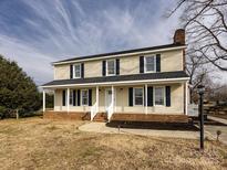 Two-story house with beige vinyl siding, dark shutters, and a brick foundation at 509 Baucom Deese Rd, Monroe, NC 28110