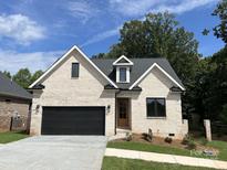 Brick house with a black garage door and landscaping at #89 Silver Trace Ln, Denver, NC 28037