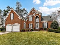 Charming two-story brick home featuring a well-manicured lawn, attached two-car garage, and classic architectural details at 11107 Balata Ct, Charlotte, NC 28269