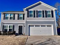 Two-story house with gray siding, black shutters, and a two-car garage at 1148 Tangle Ridge Se Dr, Concord, NC 28025
