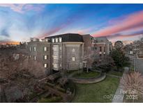Elegant brick condominium building featuring well-manicured landscaping and symmetrical design against a beautiful sky at 186 Cherokee Rd, Charlotte, NC 28207