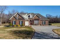 Brick house with a three-car garage and landscaped lawn at 219 Society Rd, Statesville, NC 28625