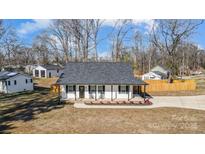 Aerial view of a charming one-story house with a gray roof and white siding at 301 Tomberlin Rd, Mount Holly, NC 28120