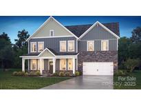 Charming two-story home featuring stone accents, a welcoming front porch, and manicured landscaping at 355 Miramar Dr, York, SC 29745