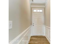 View of the entryway featuring a white front door and decorative trim with wood-look flooring at 4013 Grace Pointe Dr # 102, Wesley Chapel, NC 28079