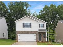 Two-story home with a stone veneer base, white siding, and a two-car garage at 5219 Reedy Ridge Rd, Charlotte, NC 28215