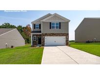 Two-story home featuring stone accents, a two-car garage, and a well-manicured lawn at 5219 Reedy Ridge Rd, Charlotte, NC 28215