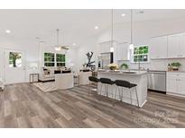 Bright, open-concept living room and kitchen with stainless steel appliances and modern finishes at 5615 Howard St, Charlotte, NC 28269