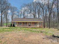 Charming brick ranch home featuring a cozy front porch and beautiful natural surroundings at 1008 E Sandy Ridge Rd, Monroe, NC 28112