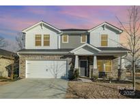 Two-story house with gray siding, stone accents, and a three-car garage at 12613 Stoneybrook Station Pkwy, Huntersville, NC 28078