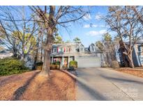 Two-story house with a large driveway and mature trees in the front yard at 2512 Heathershire Ln, Matthews, NC 28105