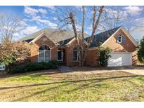 Brick home with attached garage and landscaped lawn at 4907 Foxbriar Trl, Charlotte, NC 28269