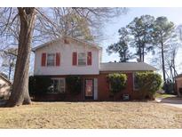 Brick ranch home with red shutters, mature trees, and well-manicured lawn at 6710 Elm Forest Dr, Charlotte, NC 28212