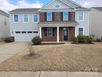 Two-story brick home with attached garage and landscaped lawn at 7822 Meridale Forest Dr, Charlotte, NC 28269