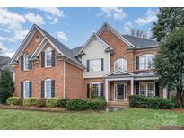 Brick two-story home with a large front yard and mature landscaping at 9929 Allyson Park Dr, Charlotte, NC 28277