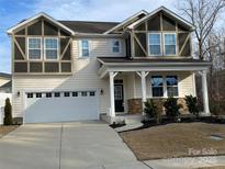 Two-story house with neutral siding, stone accents, and a white garage door at 11021 Ogden Ln, Charlotte, NC 28278