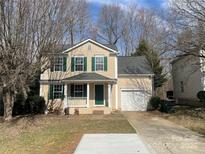 Charming two-story home with green shutters, a well-manicured lawn, and an attached garage at 11124 Northwoods Forest Dr, Charlotte, NC 28214