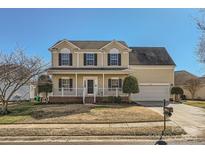 Charming two-story home with a welcoming front porch, attached garage, and well-maintained lawn at 12338 Shadow Ridge Ln, Charlotte, NC 28273