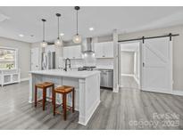 Modern kitchen with white shaker cabinets, island, and stainless steel appliances at 1325 Bostwood Ln, Concord, NC 28025