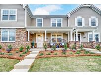 Two-story townhome with stone accents, front porch, and landscaped yard at 4004 Cheyney Park Dr, Charlotte, NC 28269