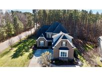 Brick home with a large, tree-lined lot and driveway at 407 Blue Bay Ct, York, SC 29745