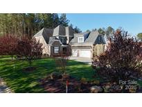 Beautiful brick home boasts lush landscaping and a three-car garage at 407 Blue Bay Ct, York, SC 29745