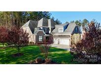 Beautiful brick home featuring a three-car garage and well-manicured lawn, perfect for suburban living at 407 Blue Bay Ct, York, SC 29745